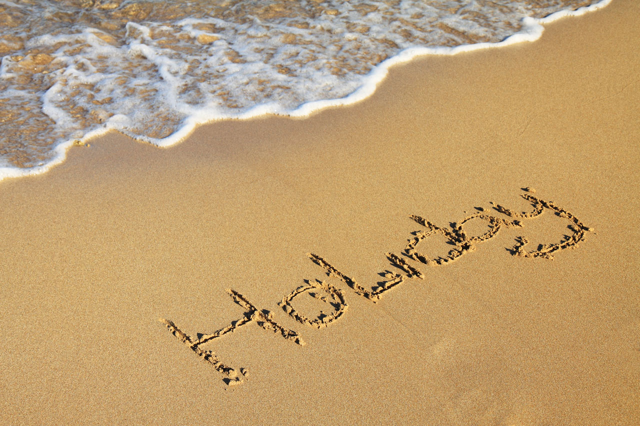 holiday word written on beach