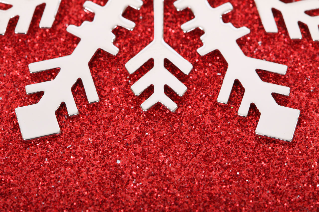 macro photo of snowflake on red glittery paper