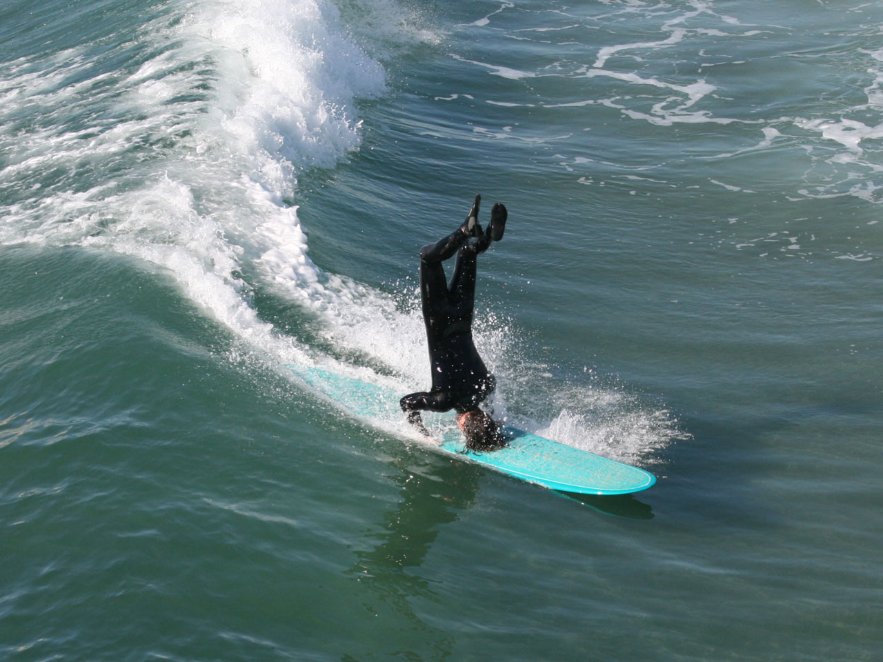 Longboard Surfer Does A Headstand