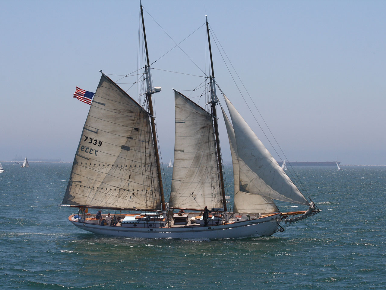 A two-masted schooner races by Belmont Shores Pier in Long Beach, California