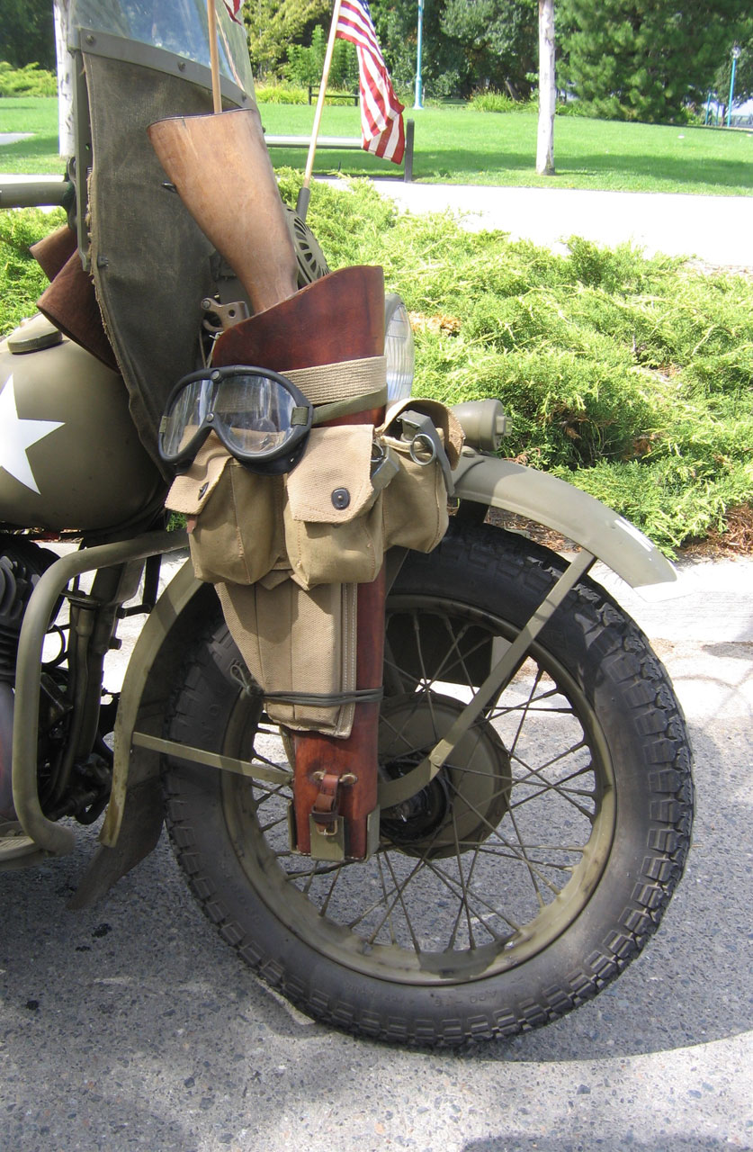 1942 WLA Harley Davidson Motorcycle Detail of Front Wheel showing the machine gun scabbard with Thompson Machine Gun, utility pack with grenade and blackout light