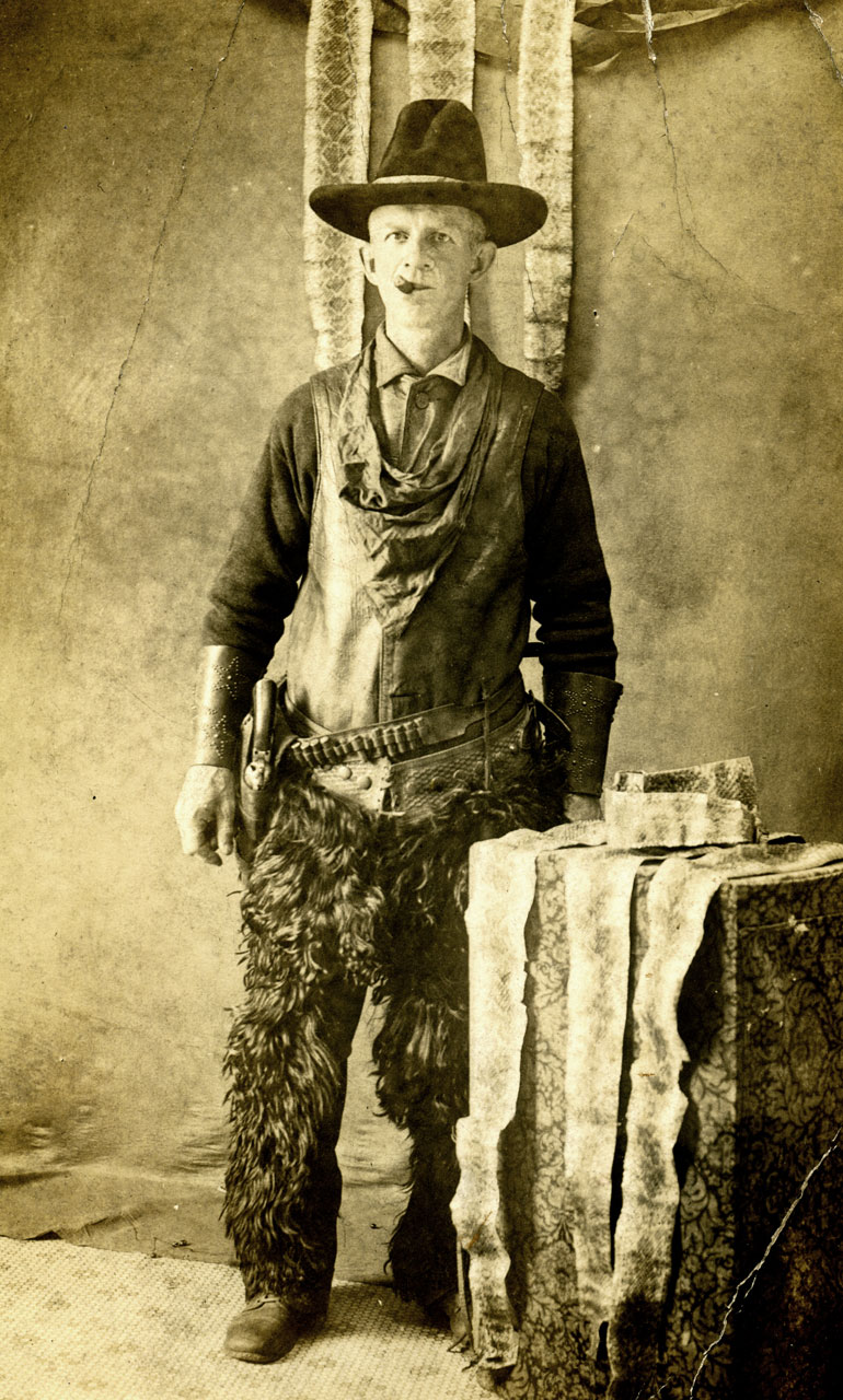 vintage postcard of a mean snake hunter, with skins to prove it