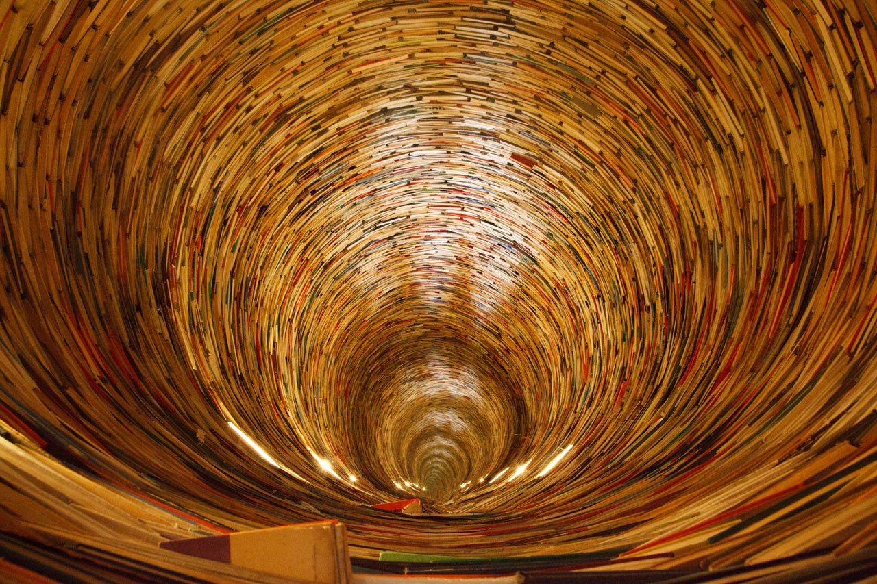 a book tunnel in Prague's library. Yes, mirrors are used to create this effect.