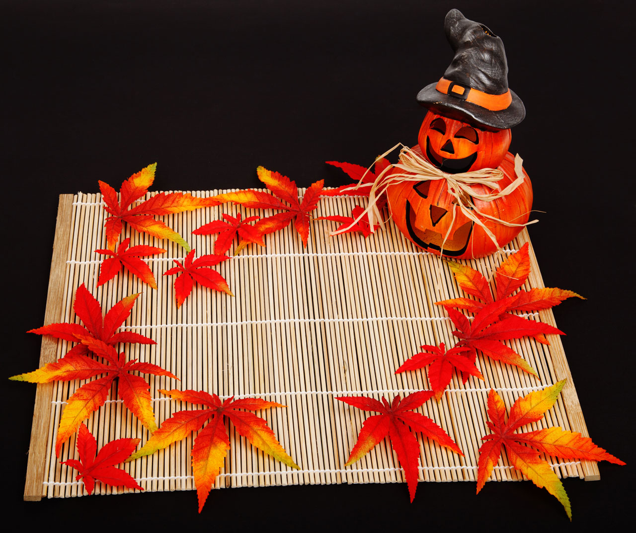 halloween autumn decoration on bamboo placemat on black background