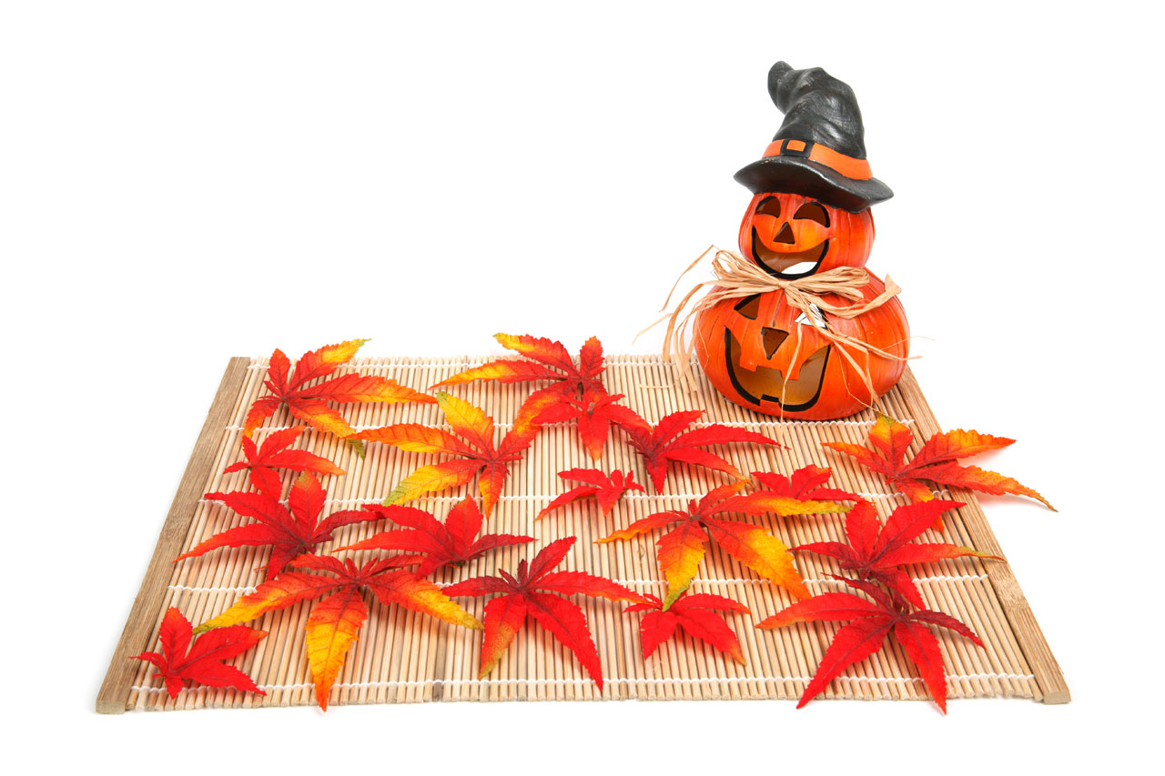 halloween decoration with autumn leaves on a placemat isolated on white background