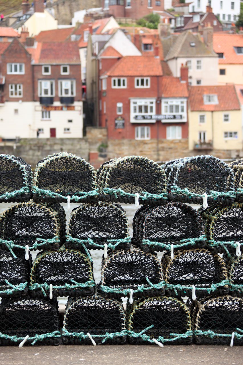 lobster pots with fishing village in the background