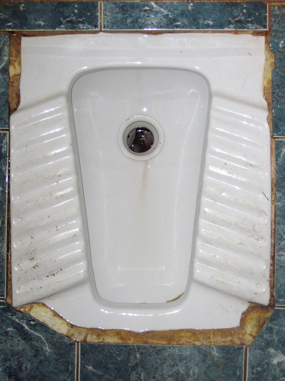 A squat toilet (also known as an Eastern, Turkish, Iranian or Natural-Position toilet). This one is in Turkey