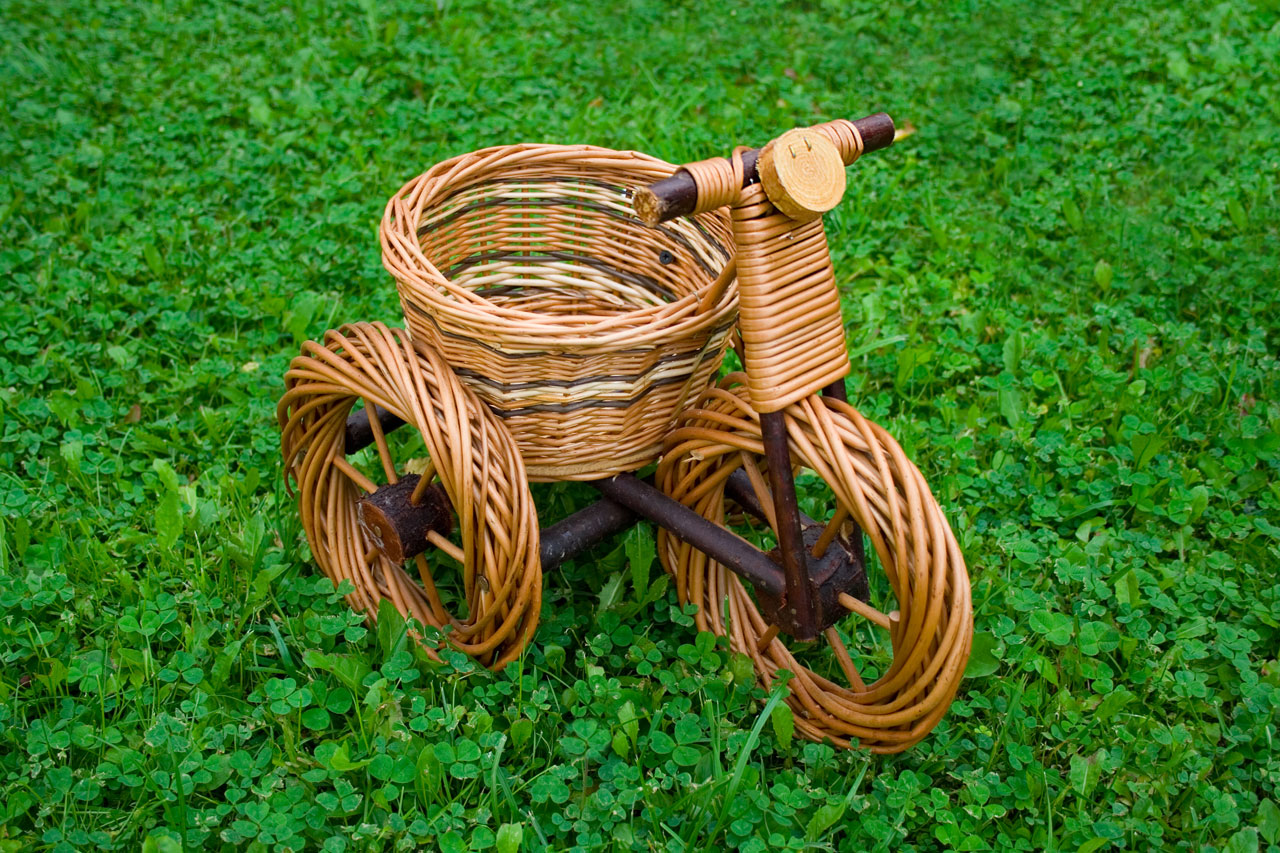 A wicker basket in a bike shape on the grass