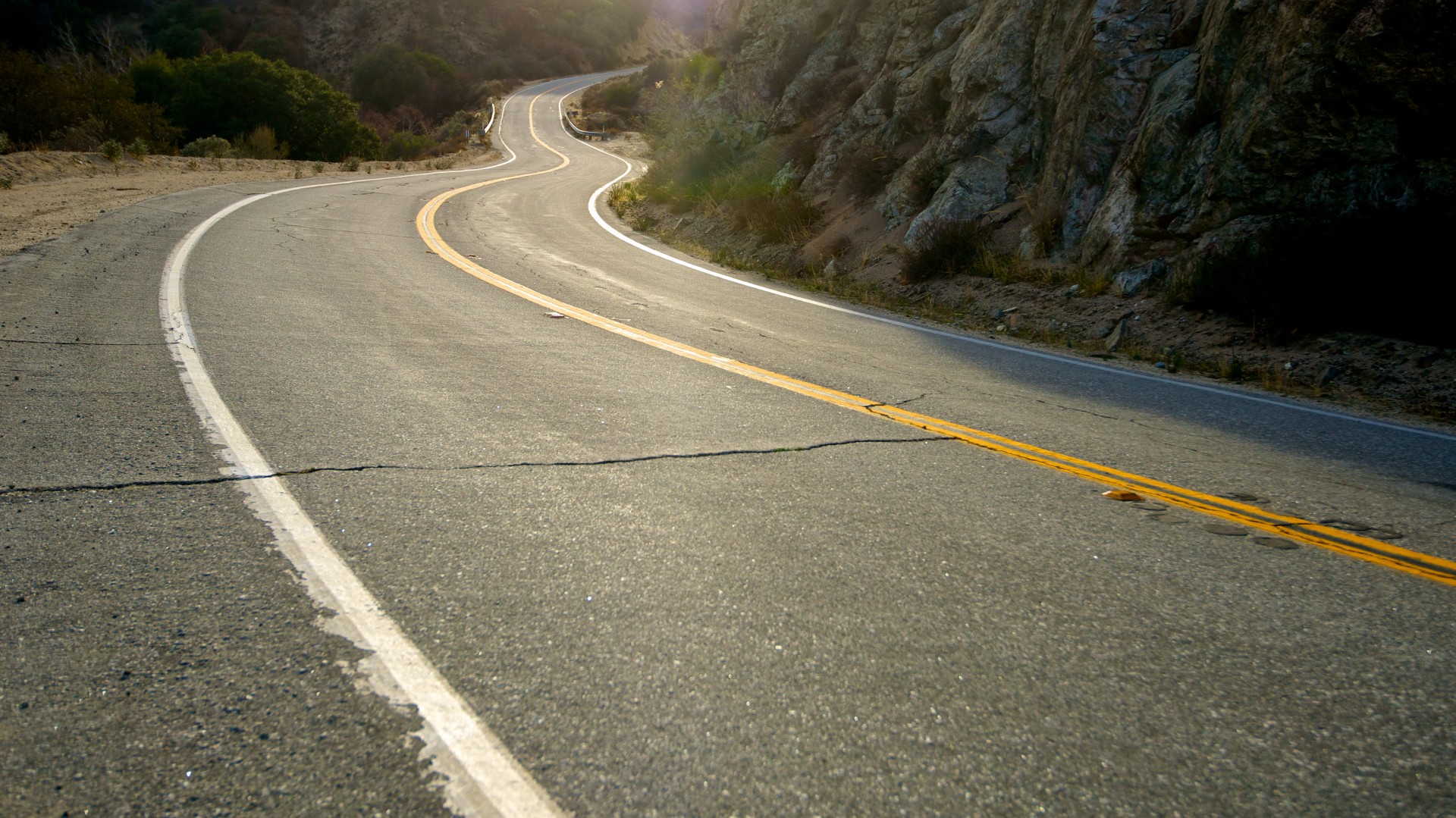 California asphalt road winds through the mountains and valleys of Angeles National Forest.