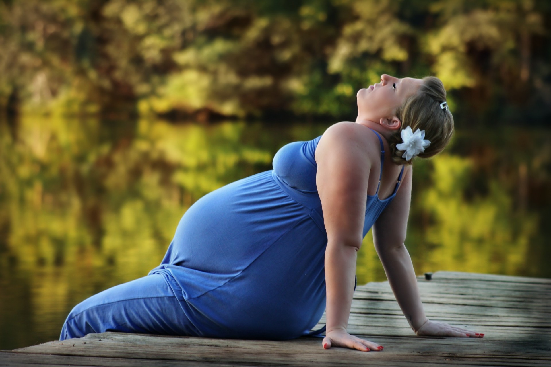 pregnant woman sitting on pier