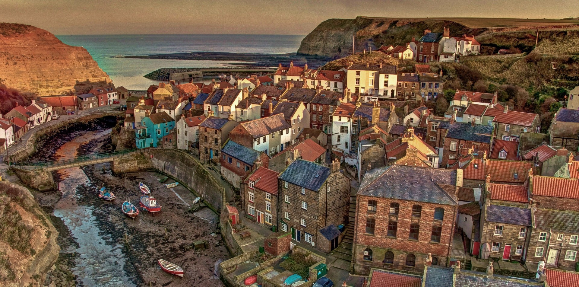 The fishing community of Staithes on the North Yorkshire Coast . Taken at sunset and enhanced with HDR .