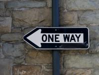 One Way Sign Against Stone Wall