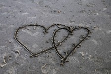 Two Overlapping Hearts In Sand