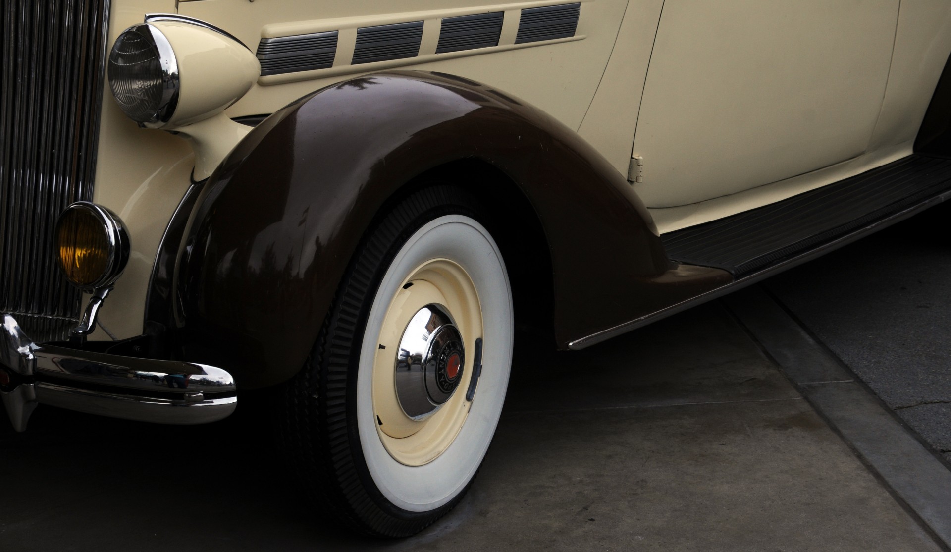 The right front side fender and whitewall tire of an old Packard car