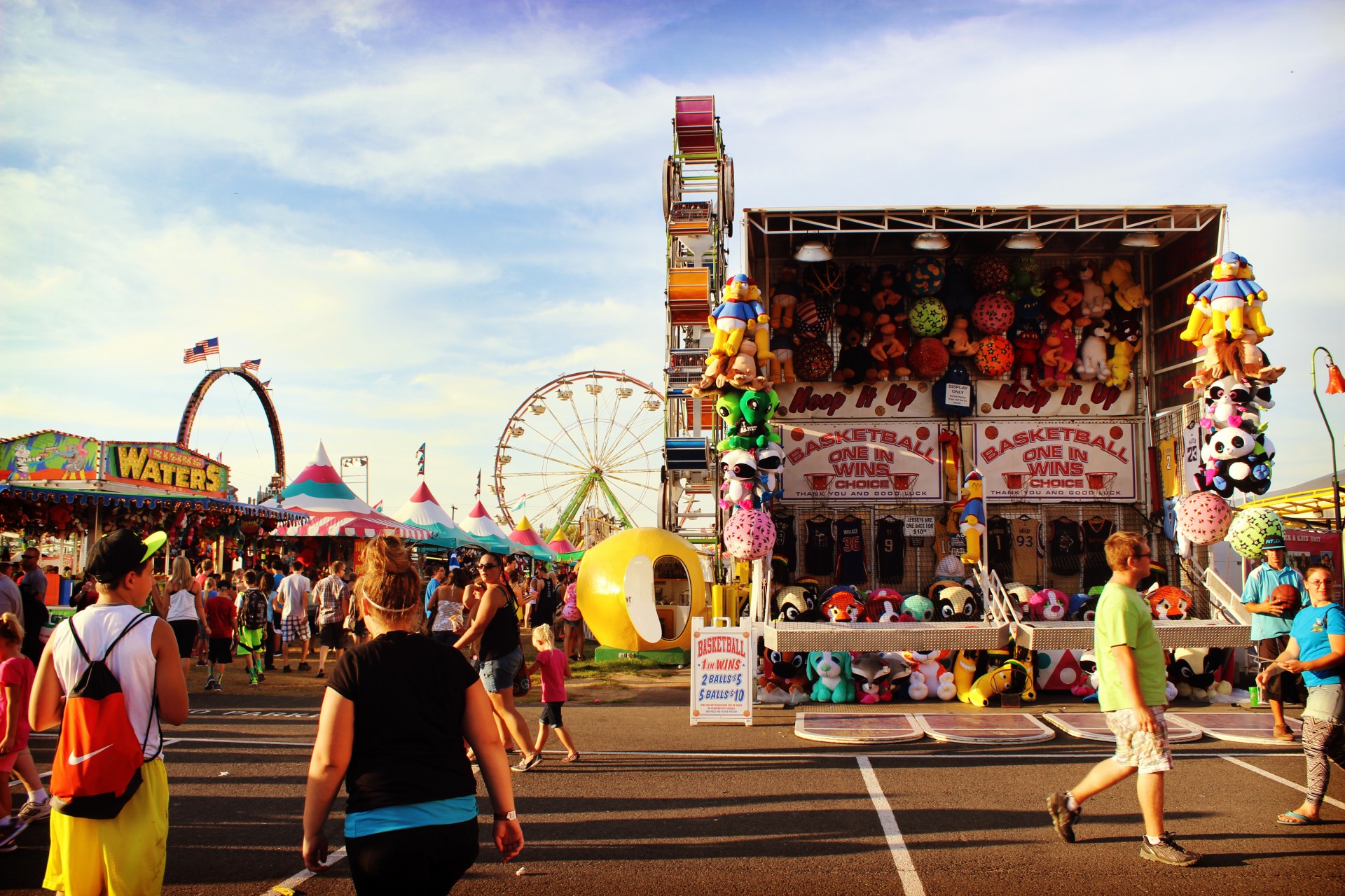 Carnival fairgrounds, people and rides.