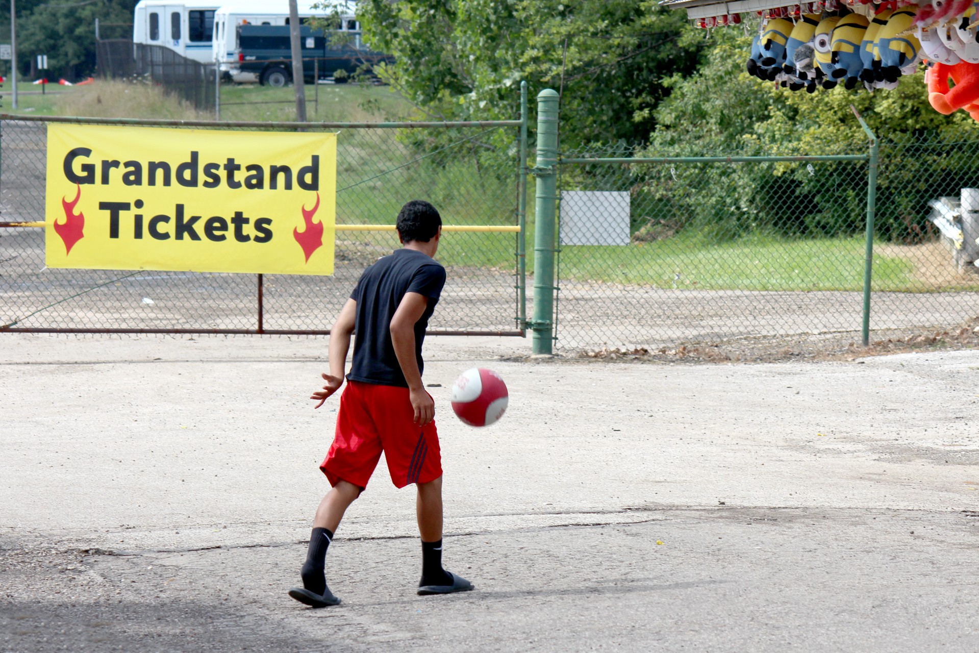Boy with football with grandstand sign in background
