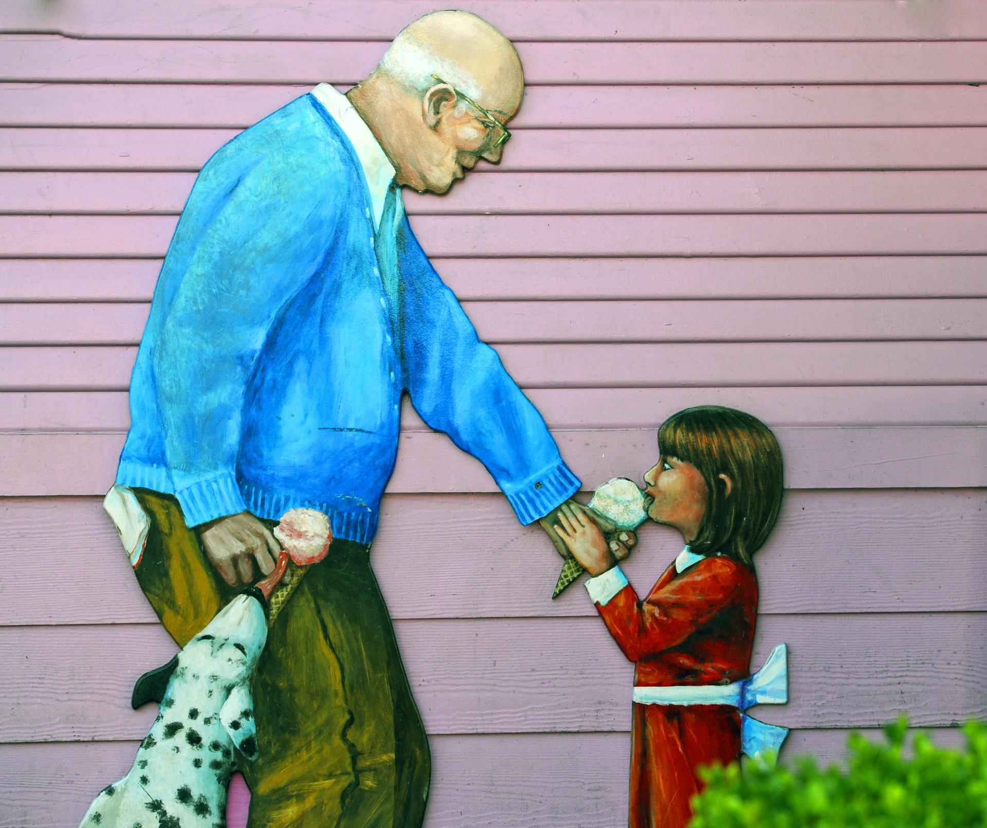 realistic looking painting on the side of an ice creme store of a grandfather, granddaughter and dalmatian dog enjoying ice creme