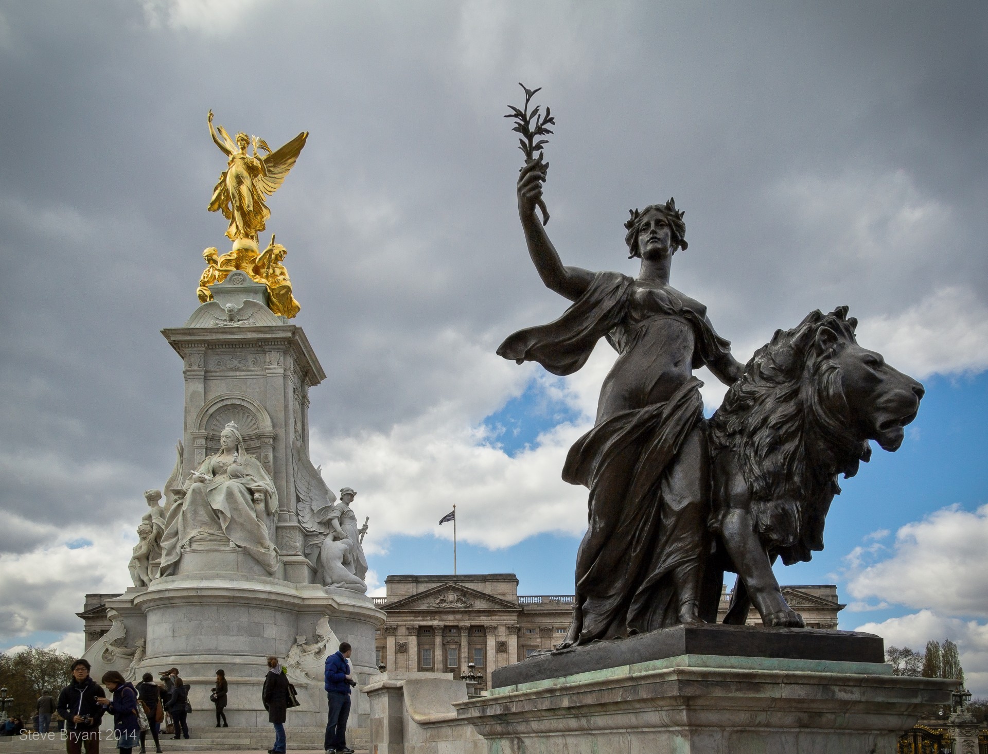 One of the statues surrounding the Queen Victoria memorial in front of Buckingham Palace in London .