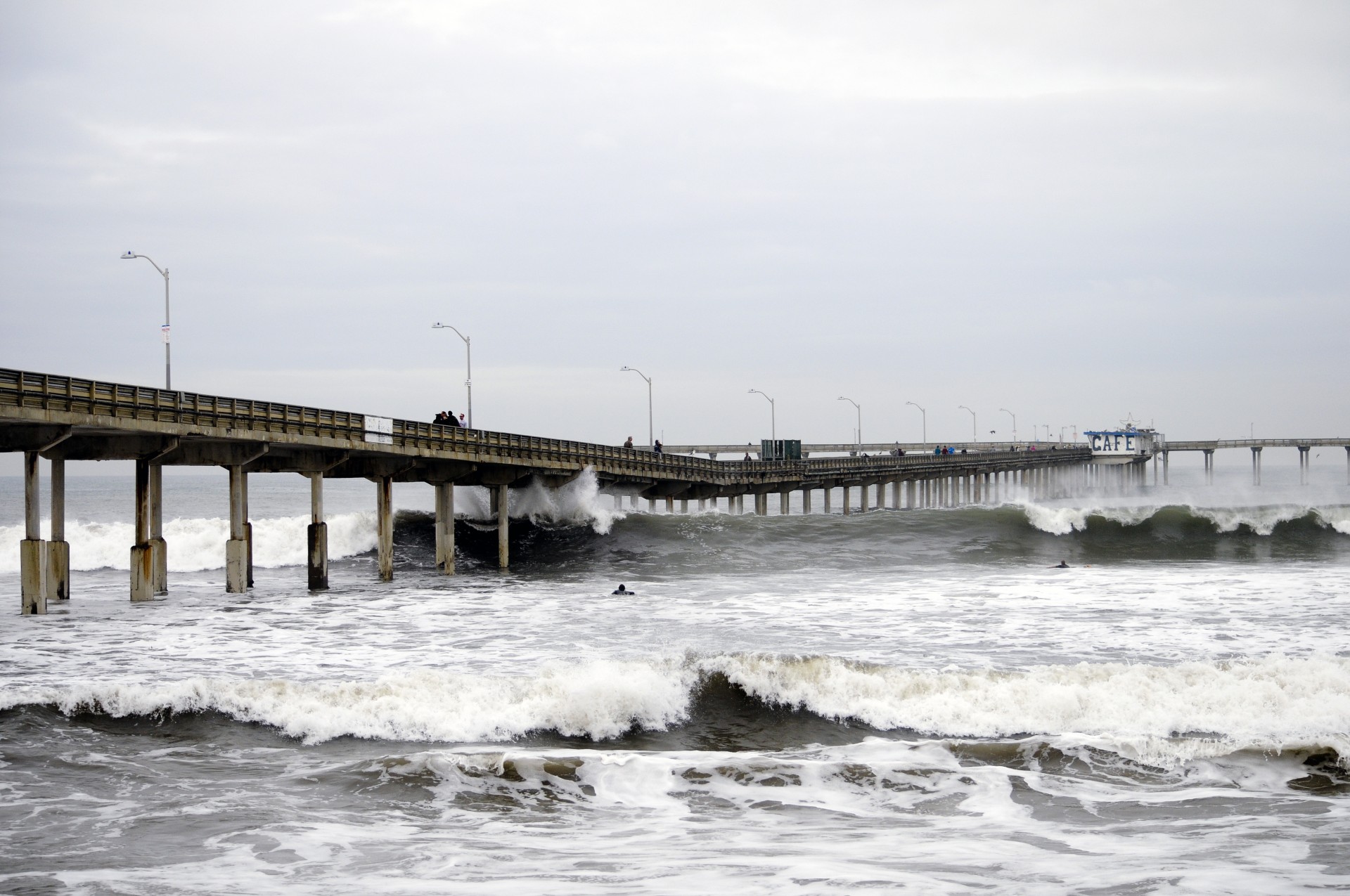 Large waves crash the pillars of the Long Beach Pier