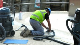 Workman Grinding Cement Walkway