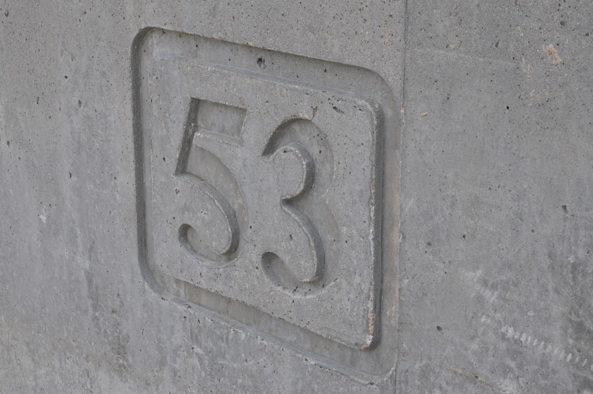 the number 53 on a wall indicating the street number from the beach