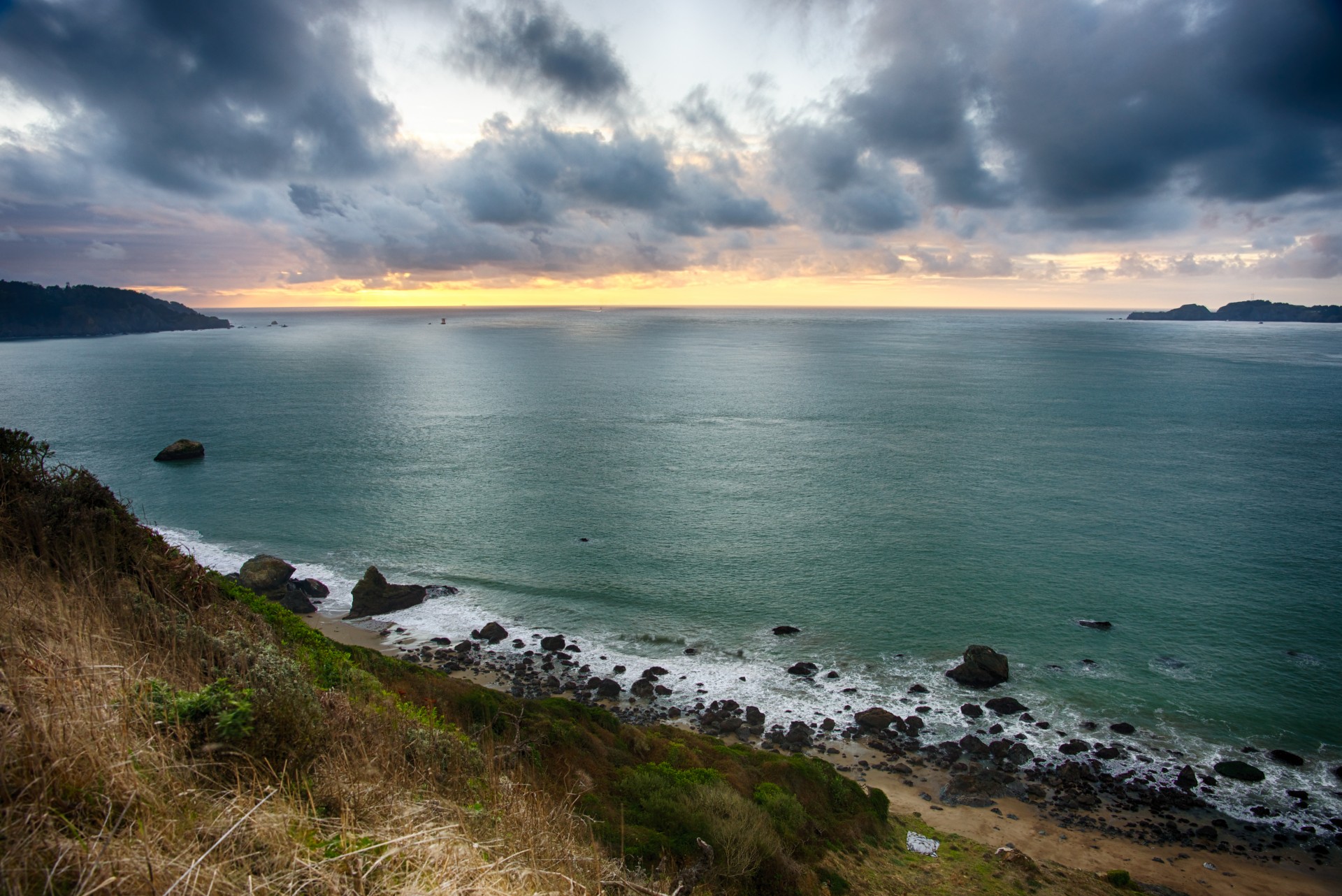 Sun sets over the Pacific Ocean on a rocky coastline near San Francisco.