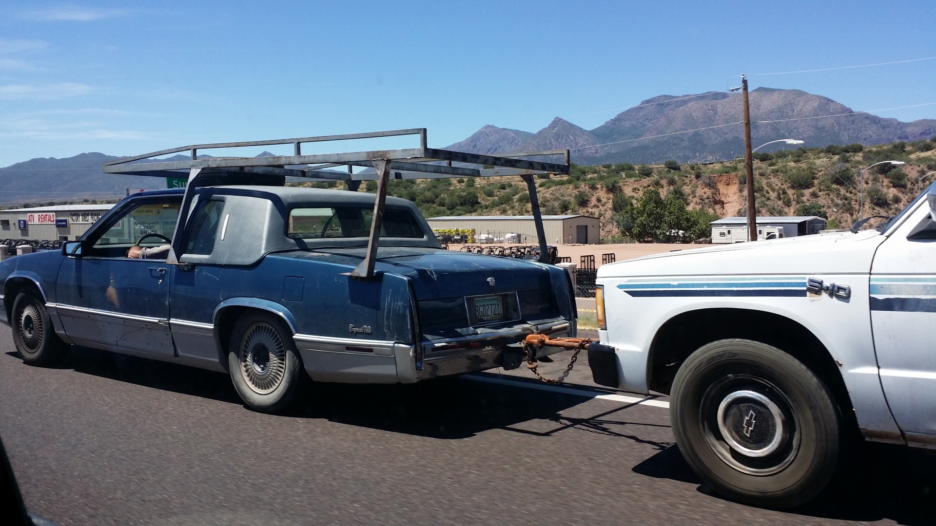 Custom Cadillac seen towing a truck on the highway in Arizona