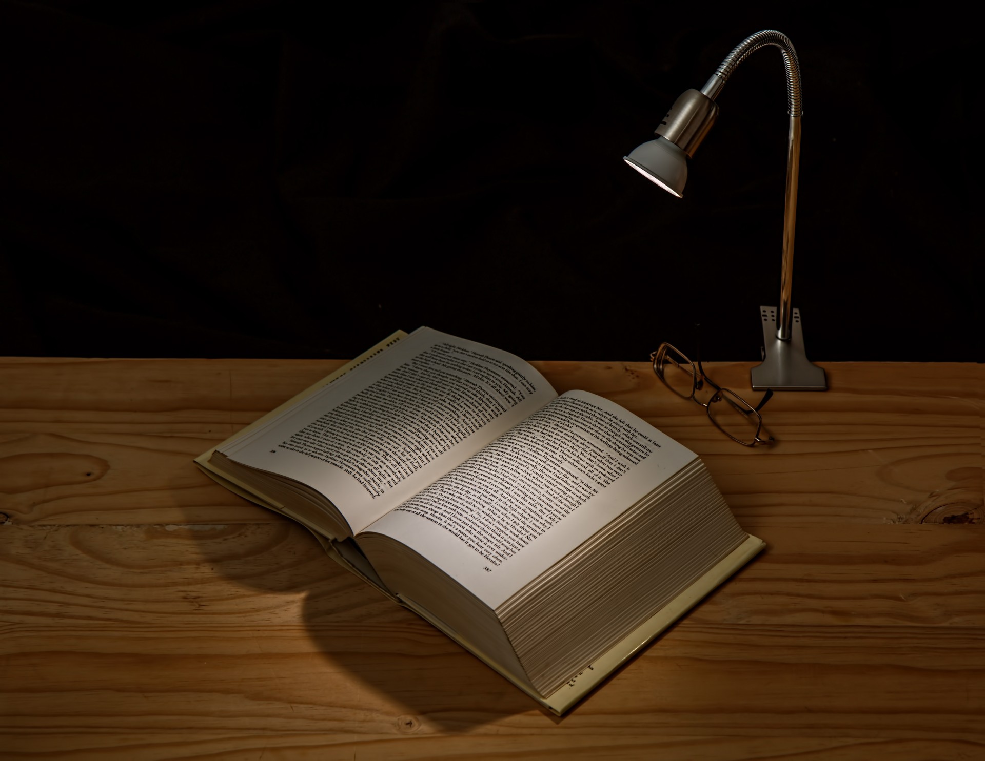 Book on desk lit by lamp