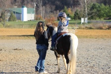 Little Girl On Horse With Mom
