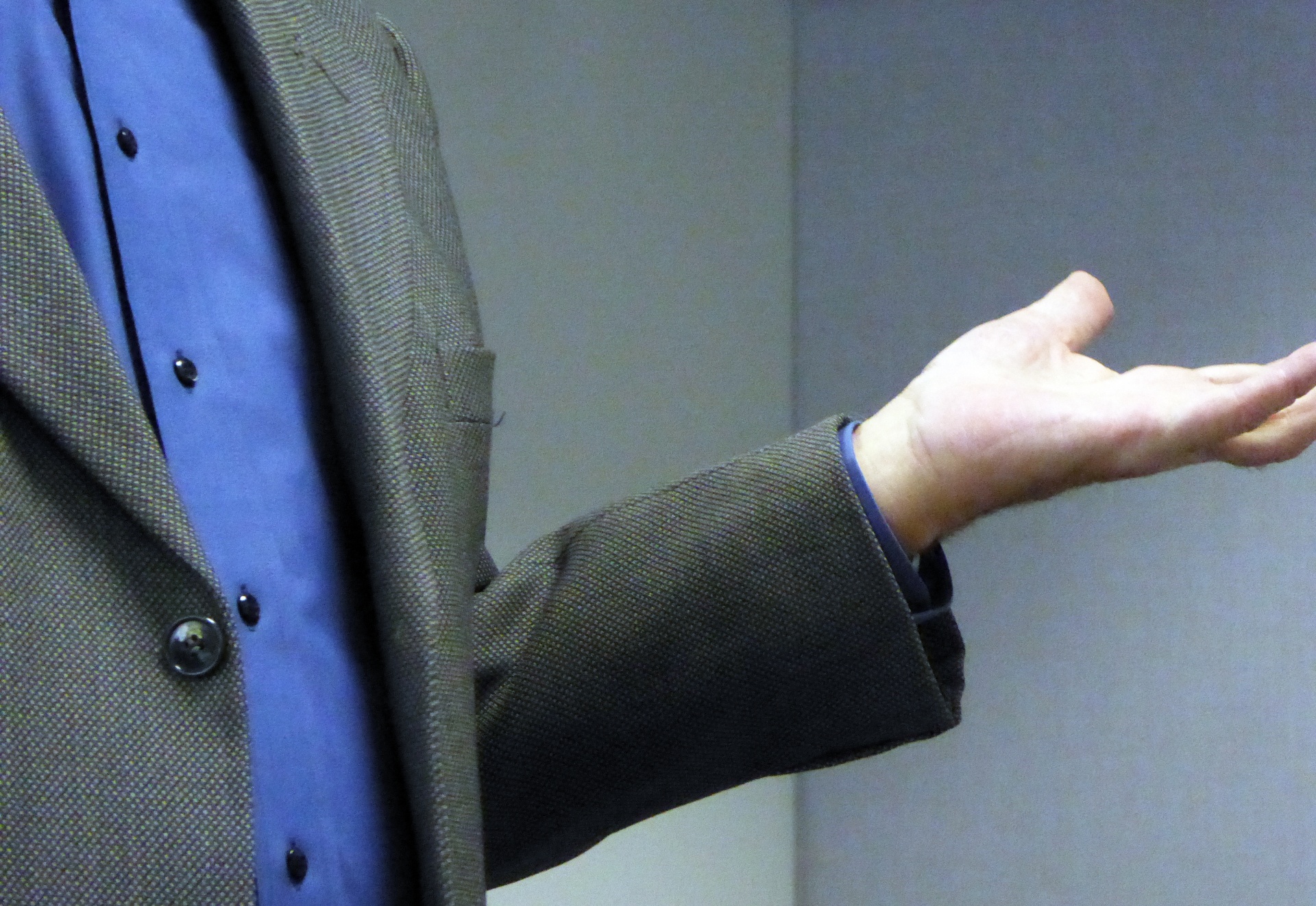 Male speaker gesturing during a presentation