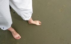 Bare Feet In Ocean Sand