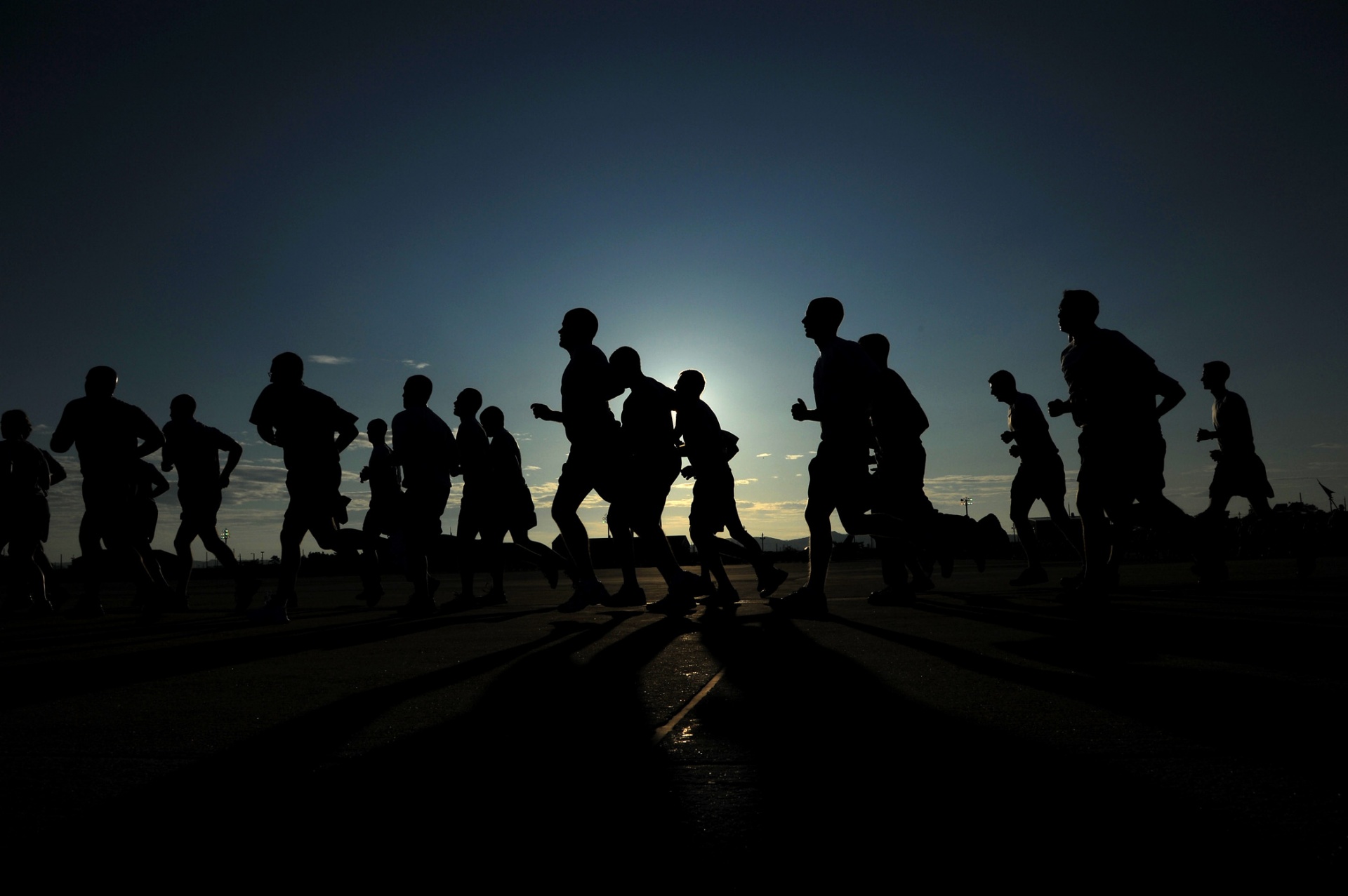 Silhouetted runners participating at sunset in running event