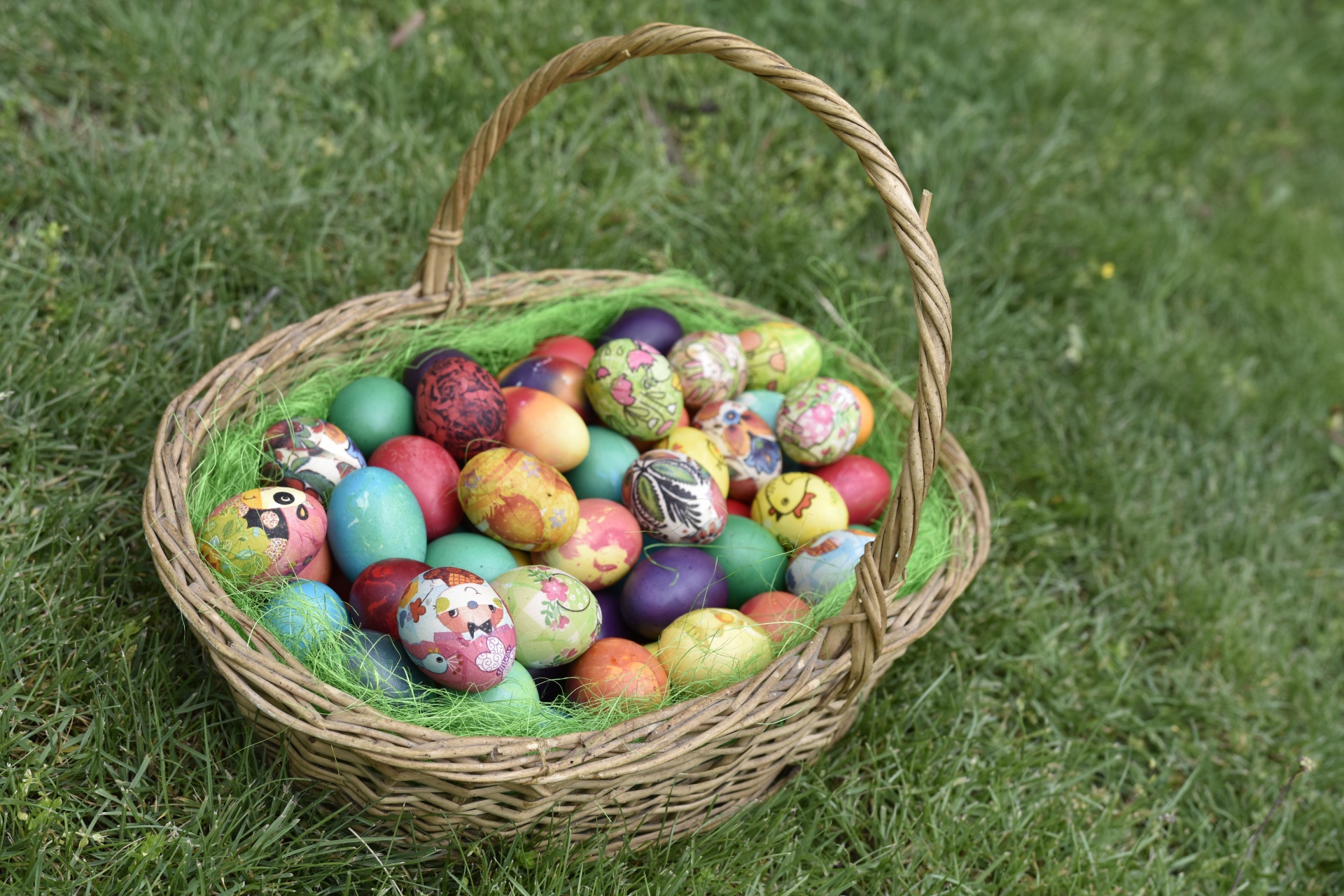 The easter bunny has left his basket in the grass.