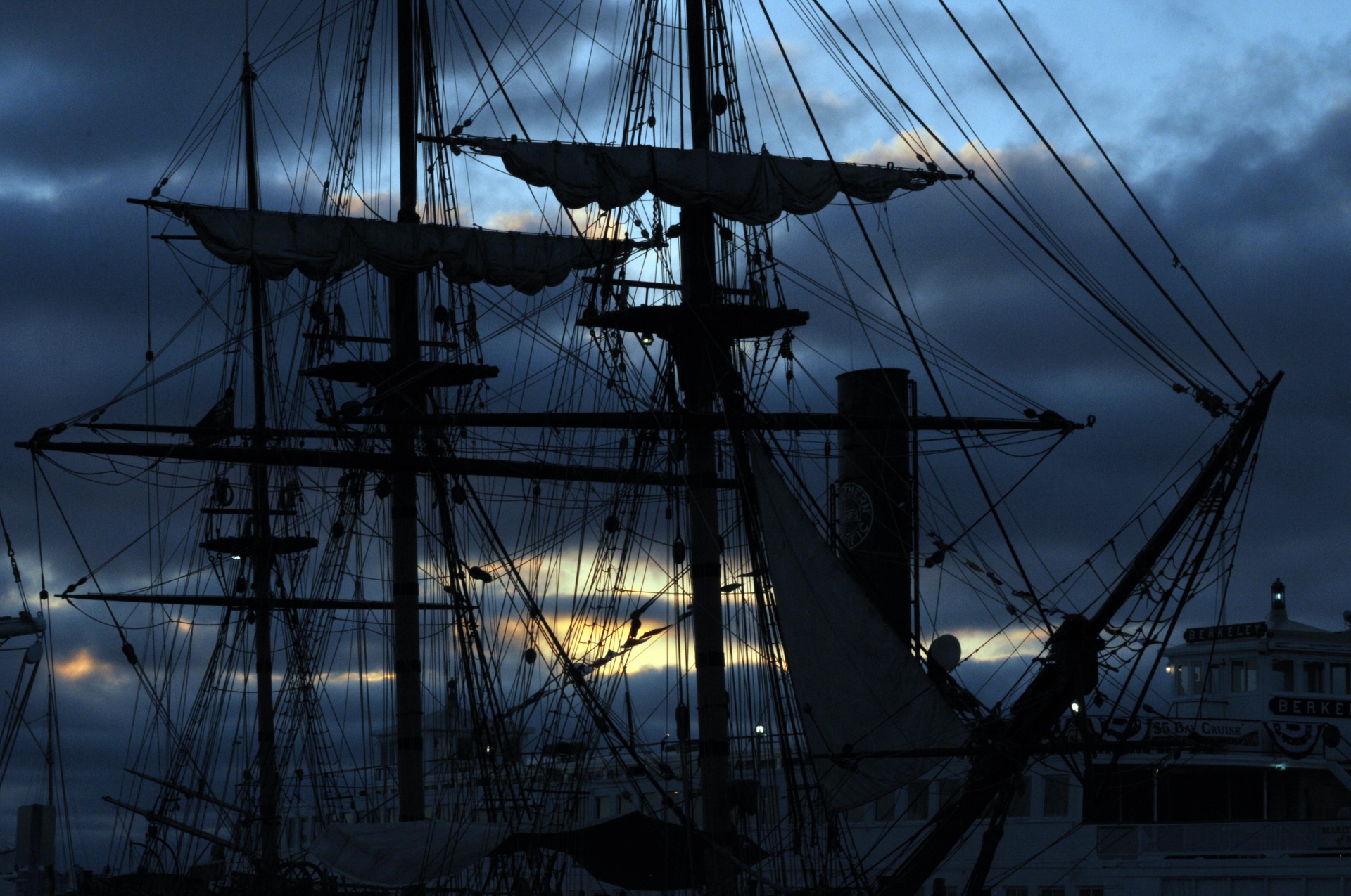 docked 1800 sailing ship silhouetted in setting sun
