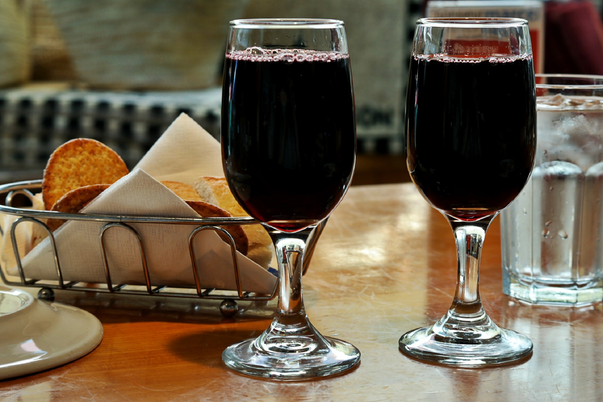 Two glasses of red wine and snacks at a small table