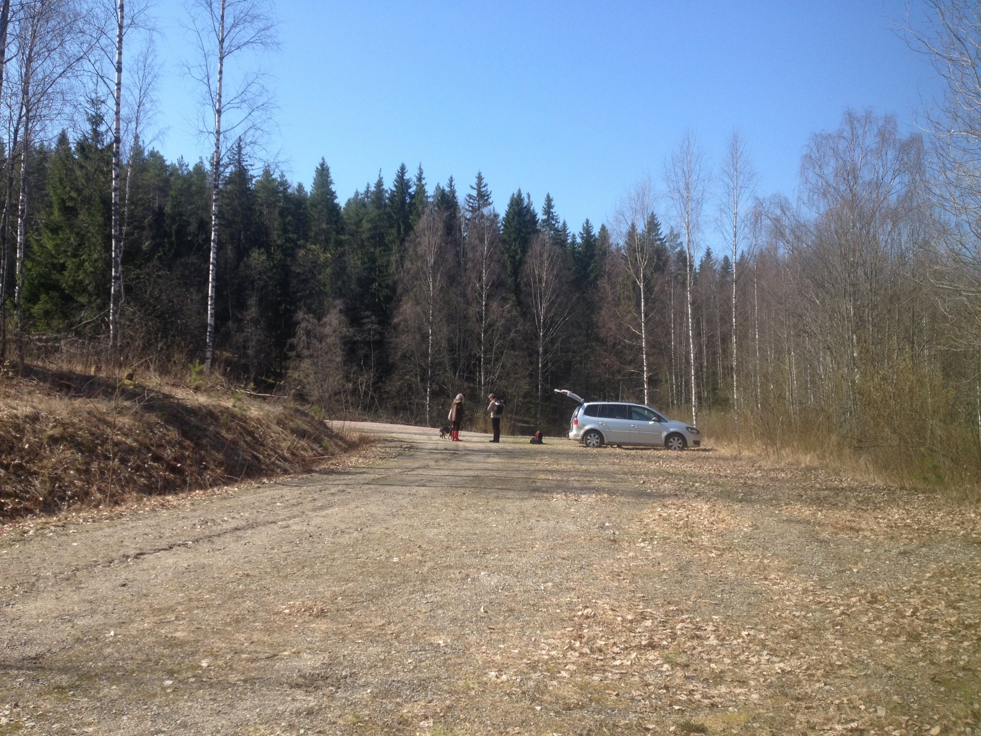 A parked car and hikers at the starting point of a hiking route in Mikkeli, Finland.
