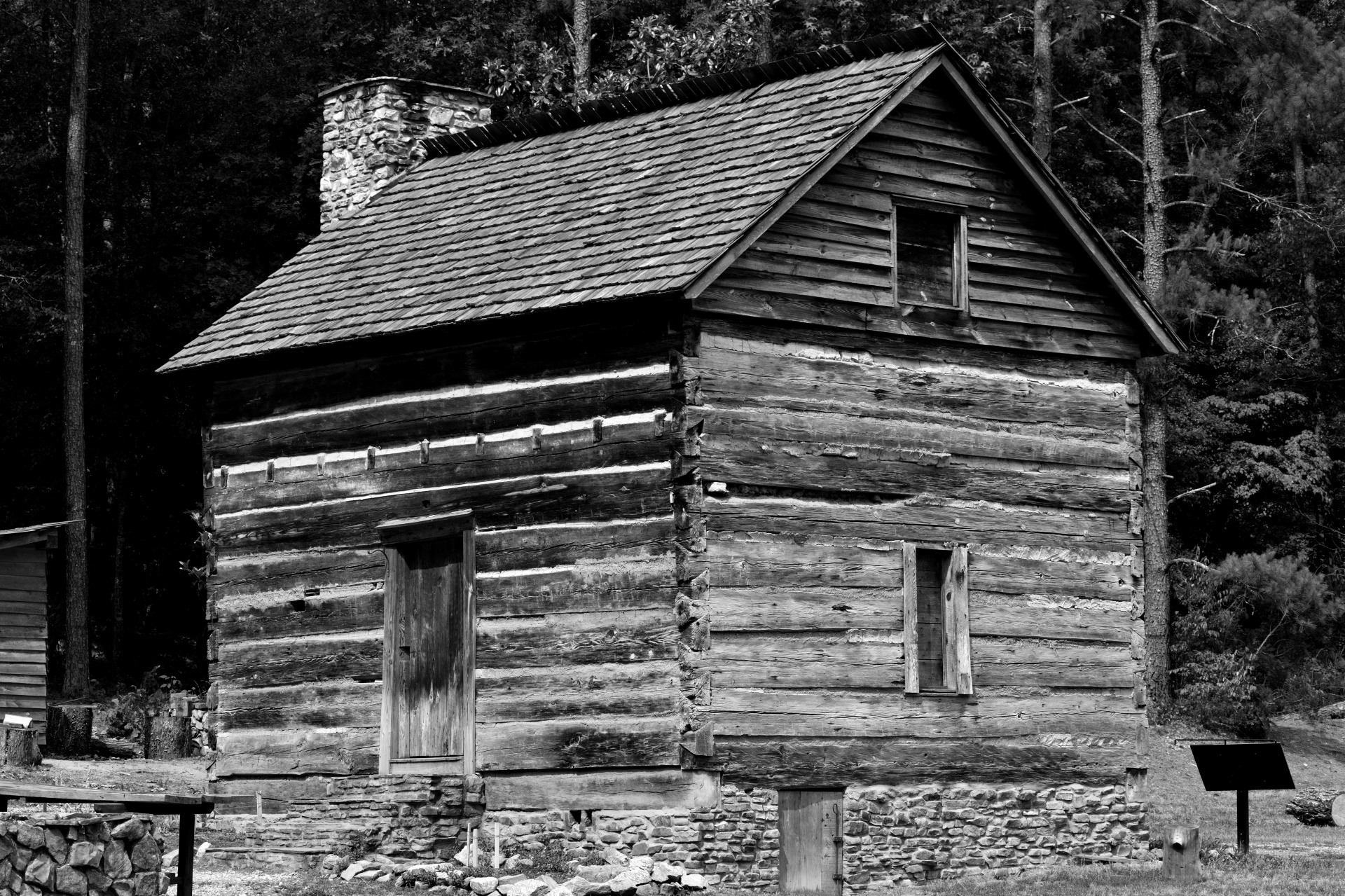 Old log cabin background rural Georgia, USA in black and white