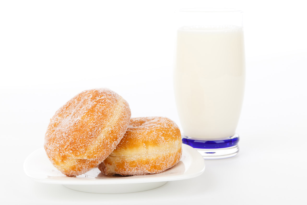 a glass of milk with yummy jelly donuts on white background