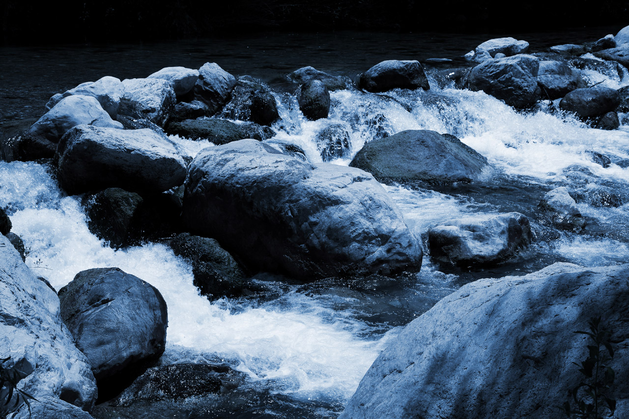 rocks in the river in bluish color