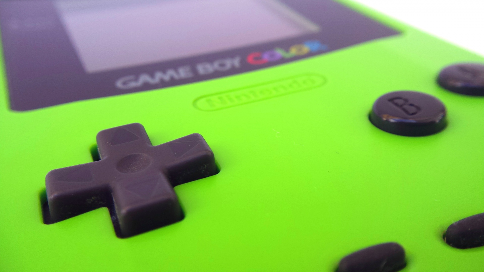 Close-up of a green Nintendo Game boy Color, focused on the D-pad controls