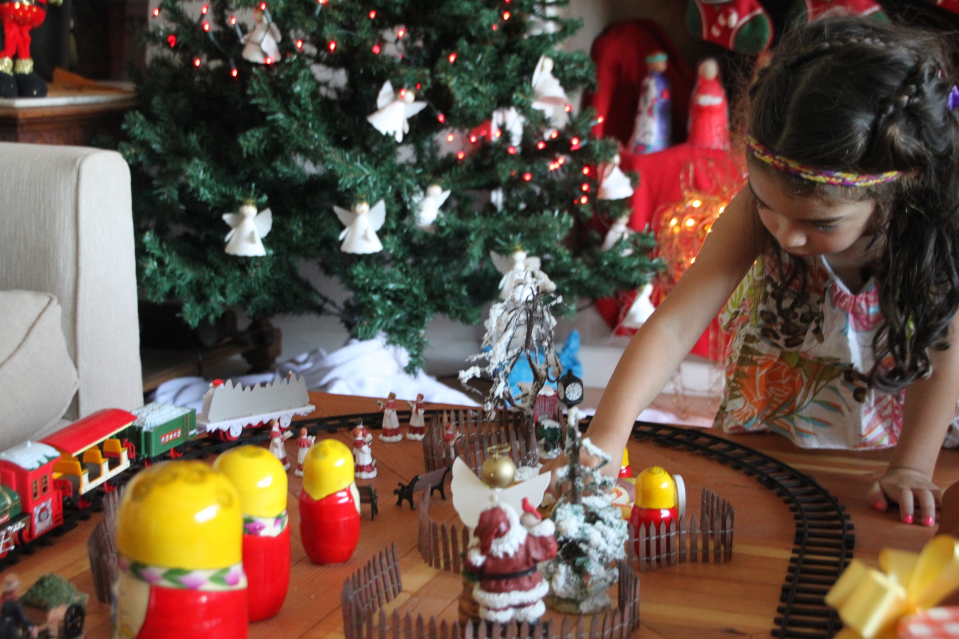 Girl playing with a train at Christmas