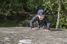 Little Boy Climbing On The Rocks