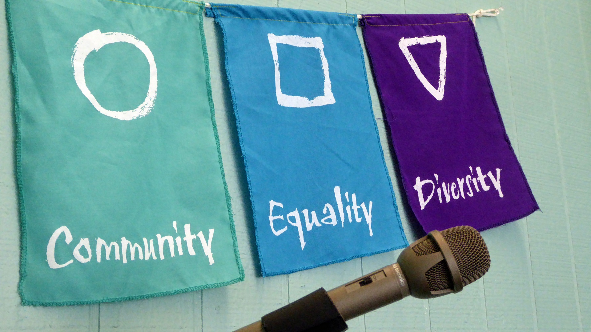 Three flags with community, equality, diversity words and microphone