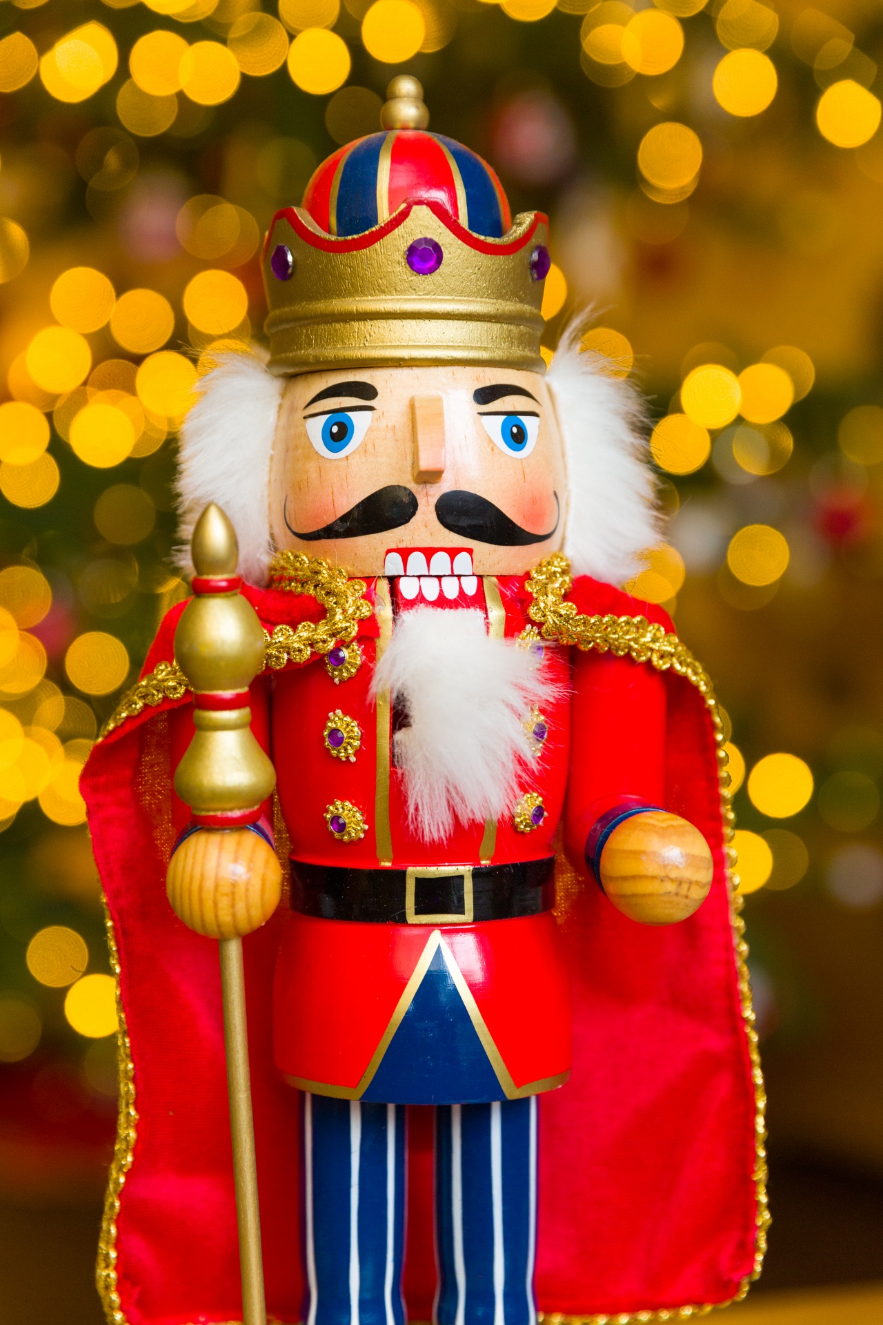 Christmas nutcracker soldier with blurred Christmas tree in the background