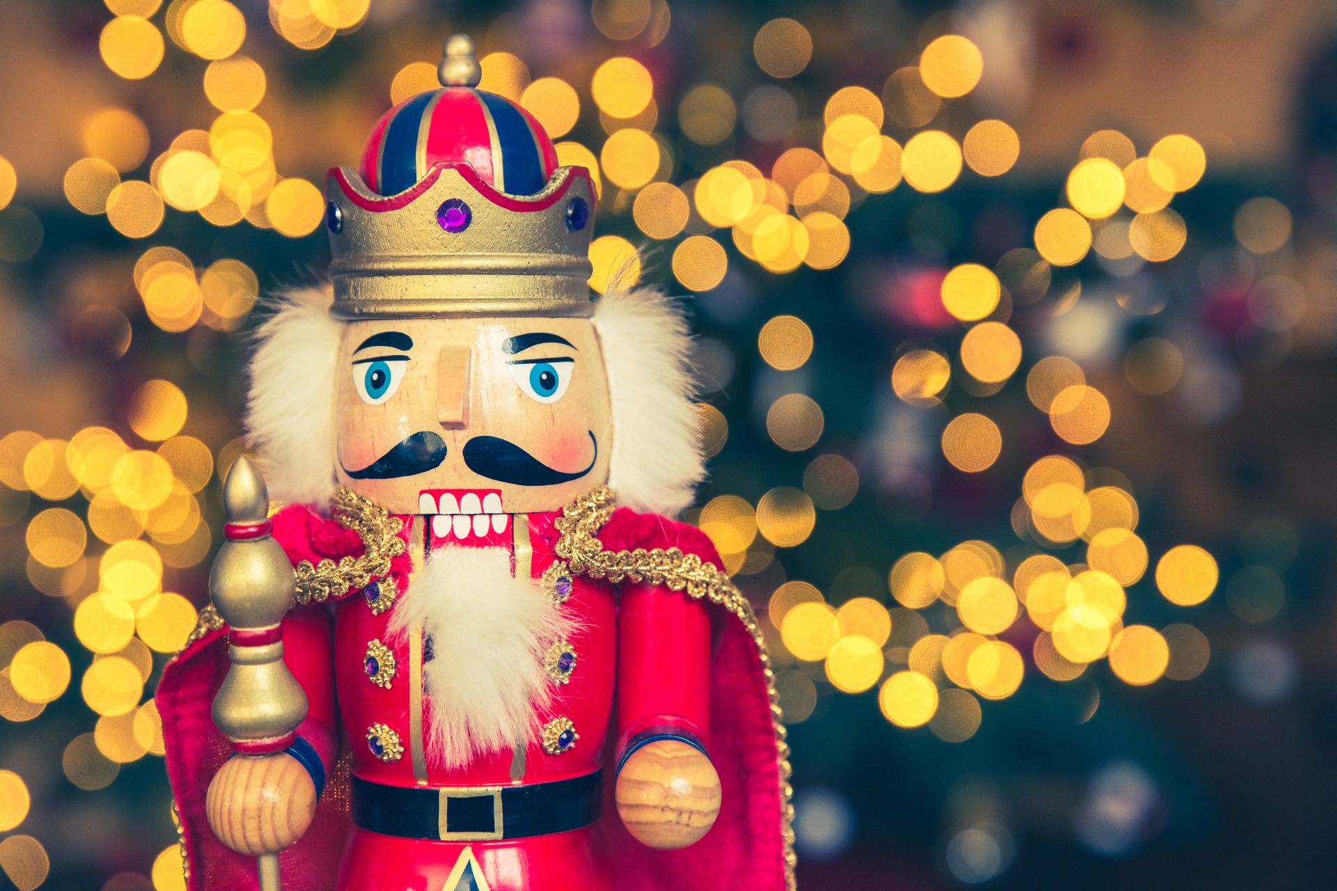 Vintage Christmas nutcracker soldier with blurred Christmas tree in the background