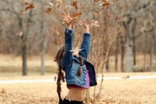 Little Girl Throwing Leaves In Air