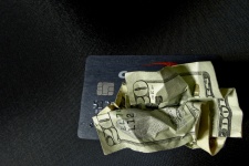 Money Crumpled Over Credit Card
