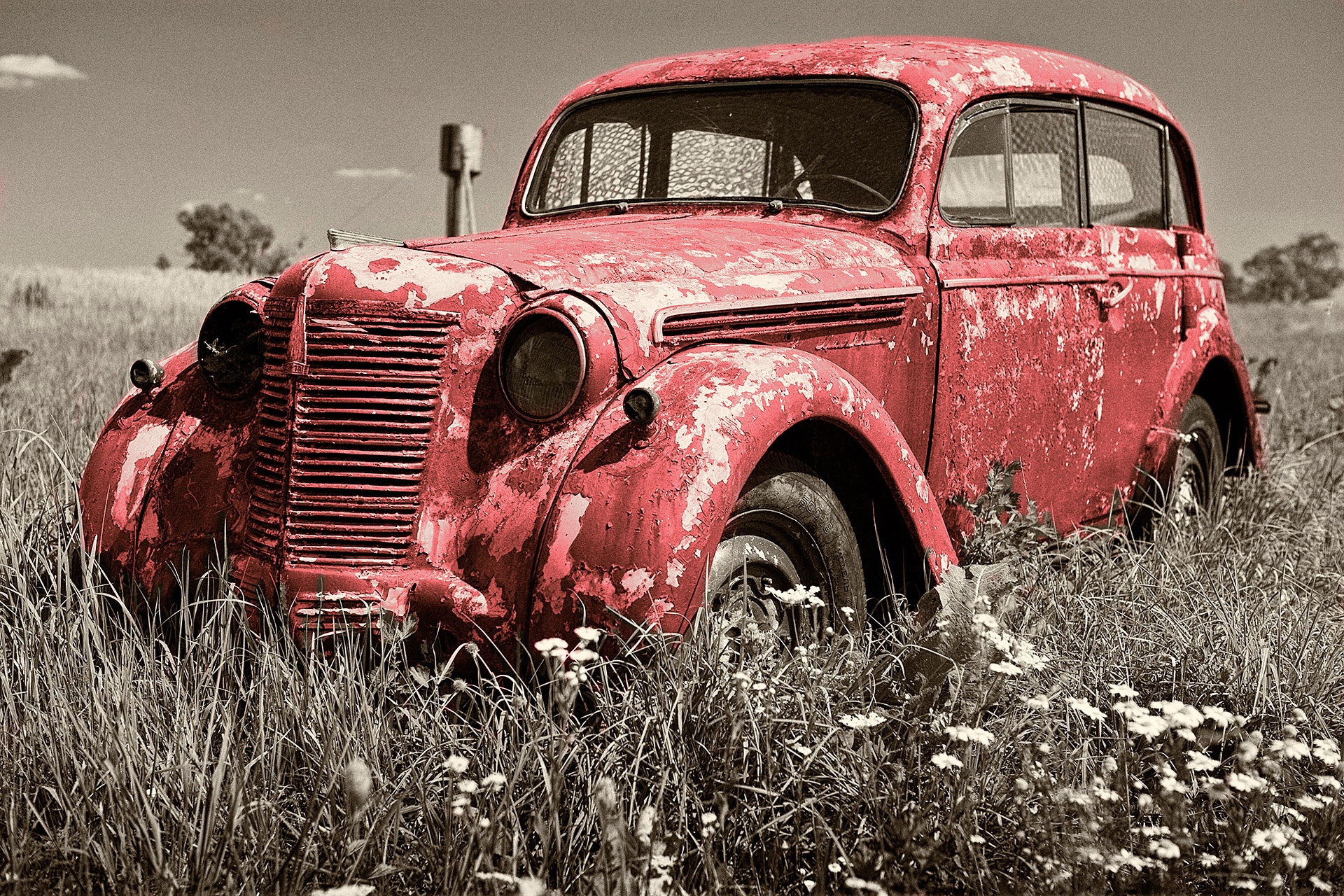 Vintage rusty old red car abandoned in field