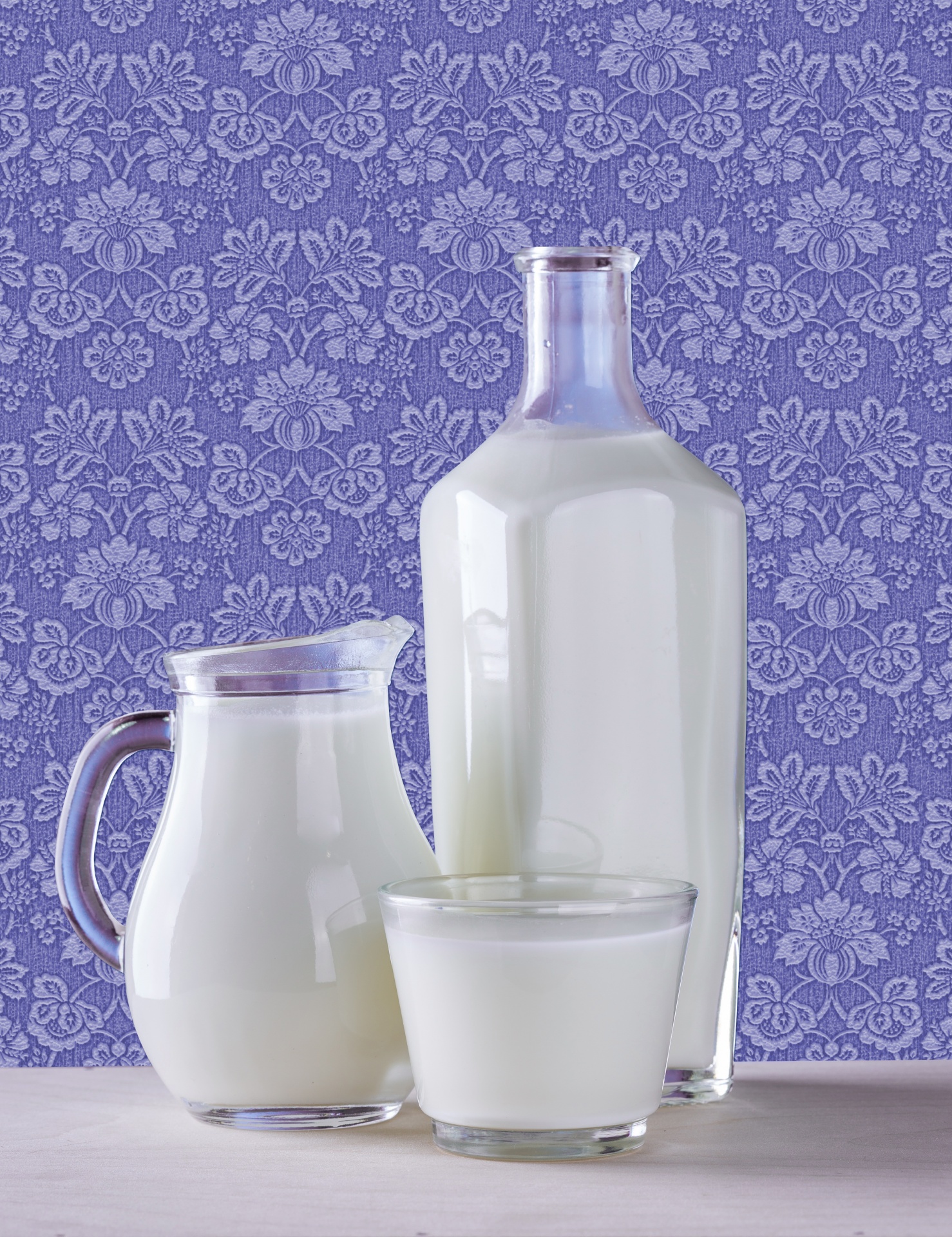 Bottle, pitcher and glass of milk on retro background