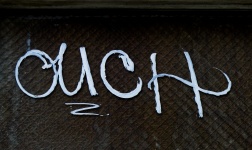 Ouch Painted On A Fence